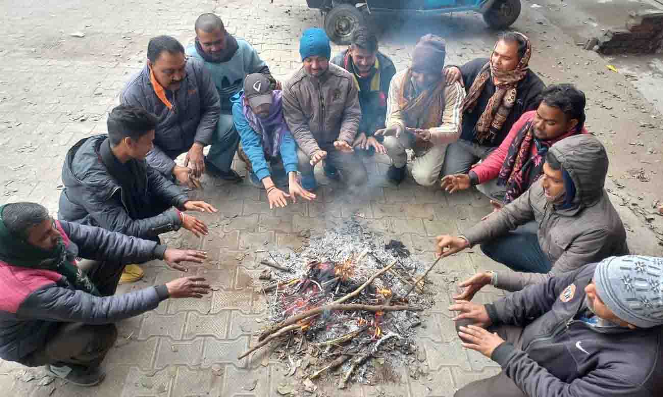 Men seek relief from the cold around a fire in Rishikesh on Friday