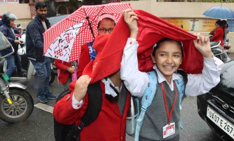 School kids innovate to shelter from the rain in Dehradun on Thursday